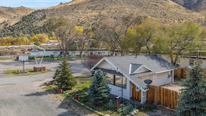 A motel with a signboard, a small building with a sloped roof, and a mountainous backdrop.