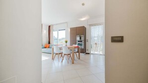 En moderne lejlighed med spiseplads, køkken og opholdsstue.