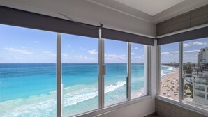 Una habitación con amplias ventanas que dan a una playa y al océano.