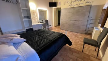 Una camera da letto con un letto, una scrivania, una sedia, un armadio e un elemento decorativo a parete.