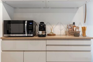 Eine Küche mit Mikrowelle, Kaffeemaschine und einer Packung Grissini.