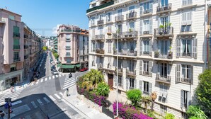 A multi-story building with balconies, a street view, and a crosswalk. - Déroulède (Nice)