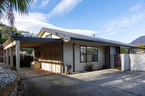 Ein modernes, eingeschossiges Haus mit überdachter Veranda, Garage und Auffahrt.