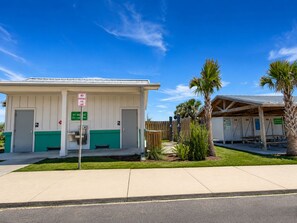 A small, single-story building with a covered outdoor seating area, a no parking fire lane sign, and a green address sign. - NEW!!! Cozy 2-bedroom house minutes to historic downtown St. Augustine & ocean. (St. Augustine)
