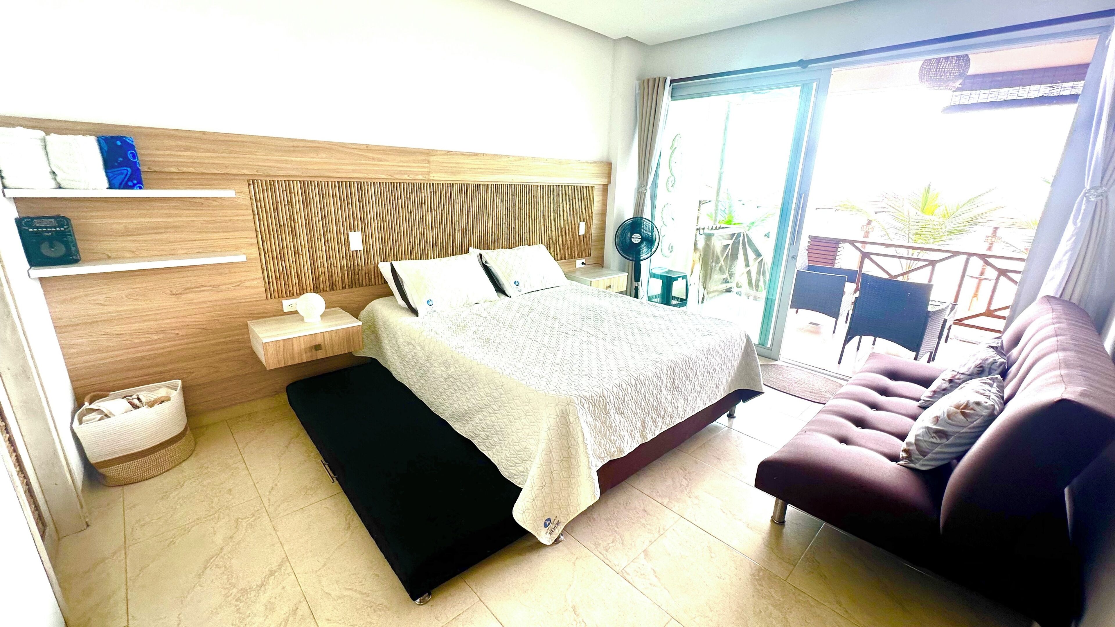 Une chambre à coucher comprenant un lit, une table de chevet, une commode et un canapé.