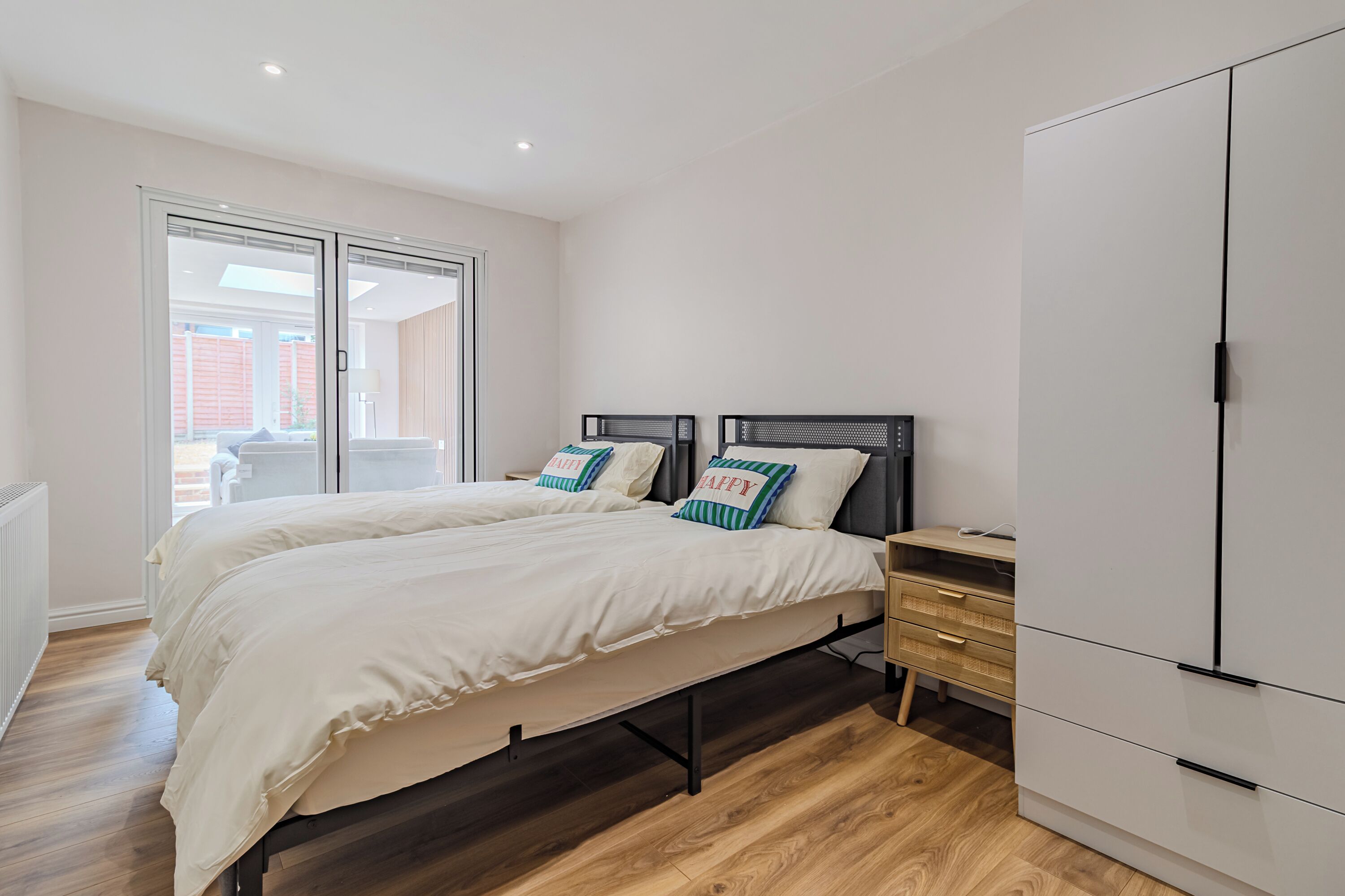 A bedroom with a bed, a wardrobe, and a desk.