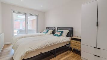 A bedroom with a bed, a wardrobe, and a desk.