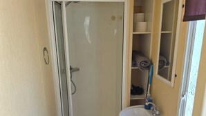 Ein kleines Badezimmer mit Dusche, Toilette und Waschbecken.
