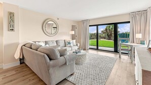 Una sala de estar con sofá, mesa de centro y vista al exterior.