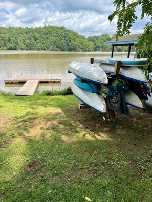 Un moll al costat d'un llac amb una plataforma de fusta i una filera de canoes.