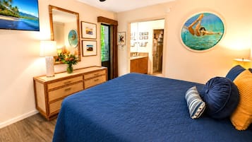 Een slaapkamer met een groot bed, een dressoir, een spiegel en een douchehoek.