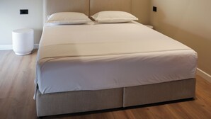 Une chambre à coucher moderne avec un grand lit, un climatiseur fixé au mur et une lampe de chevet.