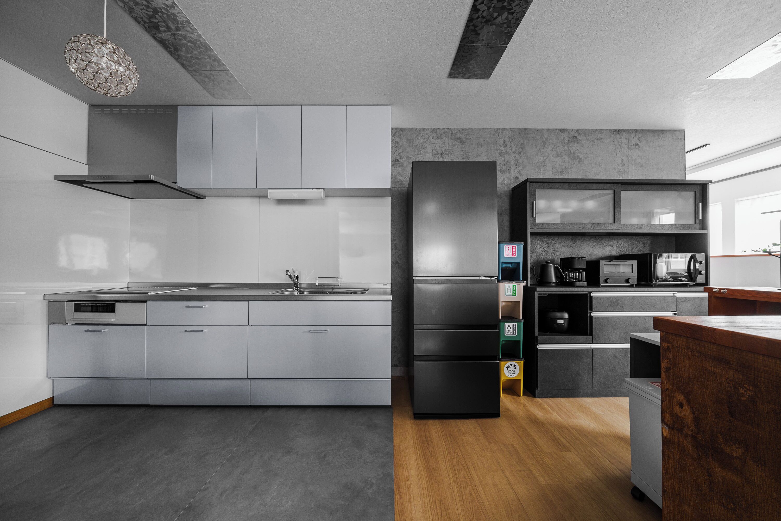 A modern kitchen with a central island, built-in appliances, and a large window.