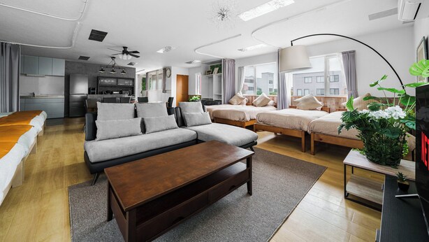 Una sala moderna con un sofá, una mesa de centro, un televisor y un comedor.