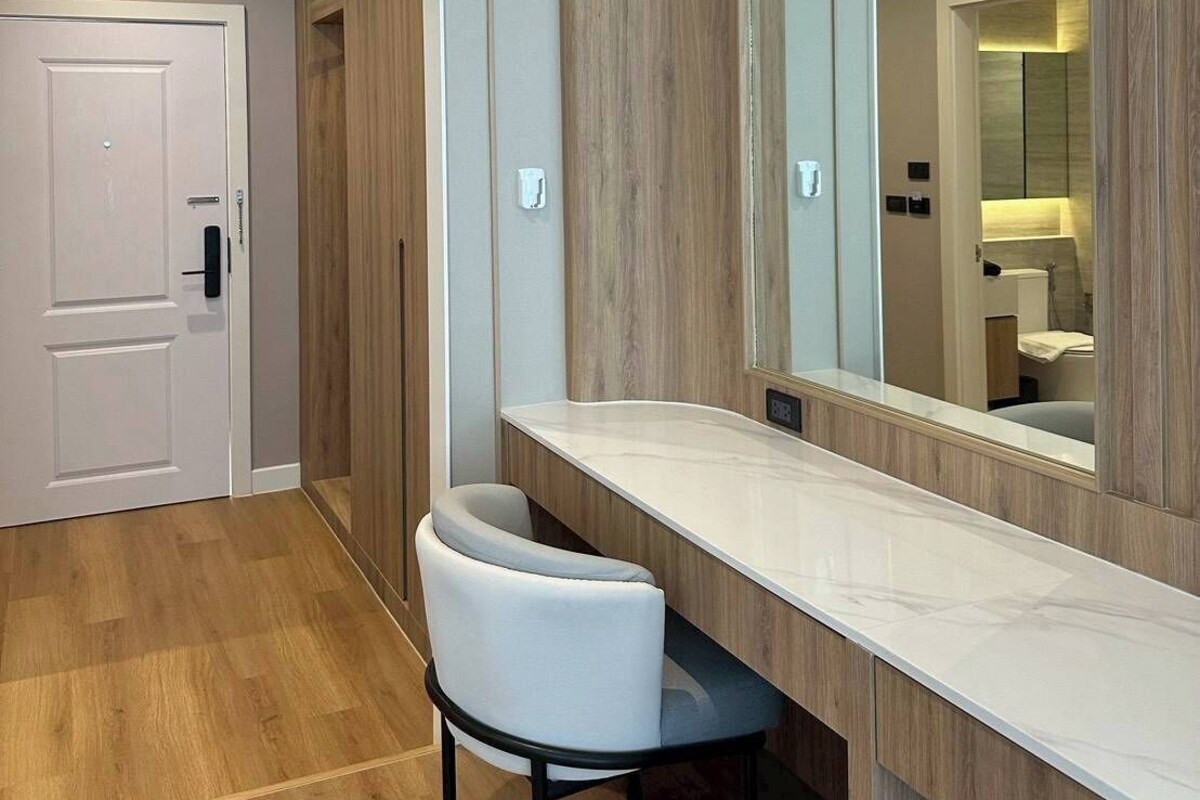 Een moderne badkamer met een wastafel, spiegel en stoel.