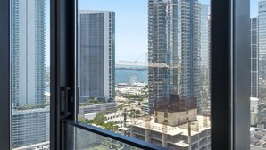 Un immeuble de grande hauteur offrant une vue sur le front de mer, avec une grande roue en arrière-plan.