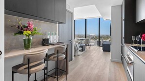 Una cucina moderna con zona bar, ampie finestre e vista sulla città.