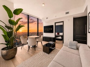 Una sala de estar moderna con vista a la ciudad, un comedor y un dormitorio.