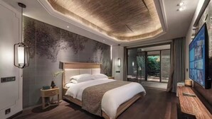 Une chambre d’hôtel moderne dotée d’un grand lit, d’une télévision et offrant une vue sur l’extérieur.