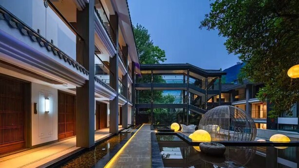 Un hôtel moderne doté d’une cour intérieure, d’une piscine et de coins salons aménagés dans un style traditionnel.