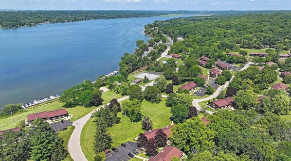 Vista aerea di una zona residenziale con case, una strada e un lago.