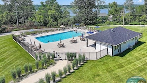 Ein Wohnhaus mit Swimmingpool, überdachter Terrasse und Seeblick.