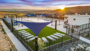 A rooftop pool area with a blue shade sail, outdoor seating, and a view of the surrounding landscape. - Skyline Resort, Private Hot tub, Resort amenities! (Washington)
