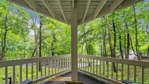 A covered wooden deck with benches, surrounded by a forested area. - Fontana Home With Pool and Hot Tub Minutes from the Lake (Fontana-on-Geneva Lake)