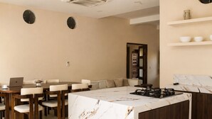 A modern kitchen with a marble island, wooden chairs, a laptop, and a built-in stove. - Perfect 4-bedroom house with AC in enchanting Cartagena (Cartagena)