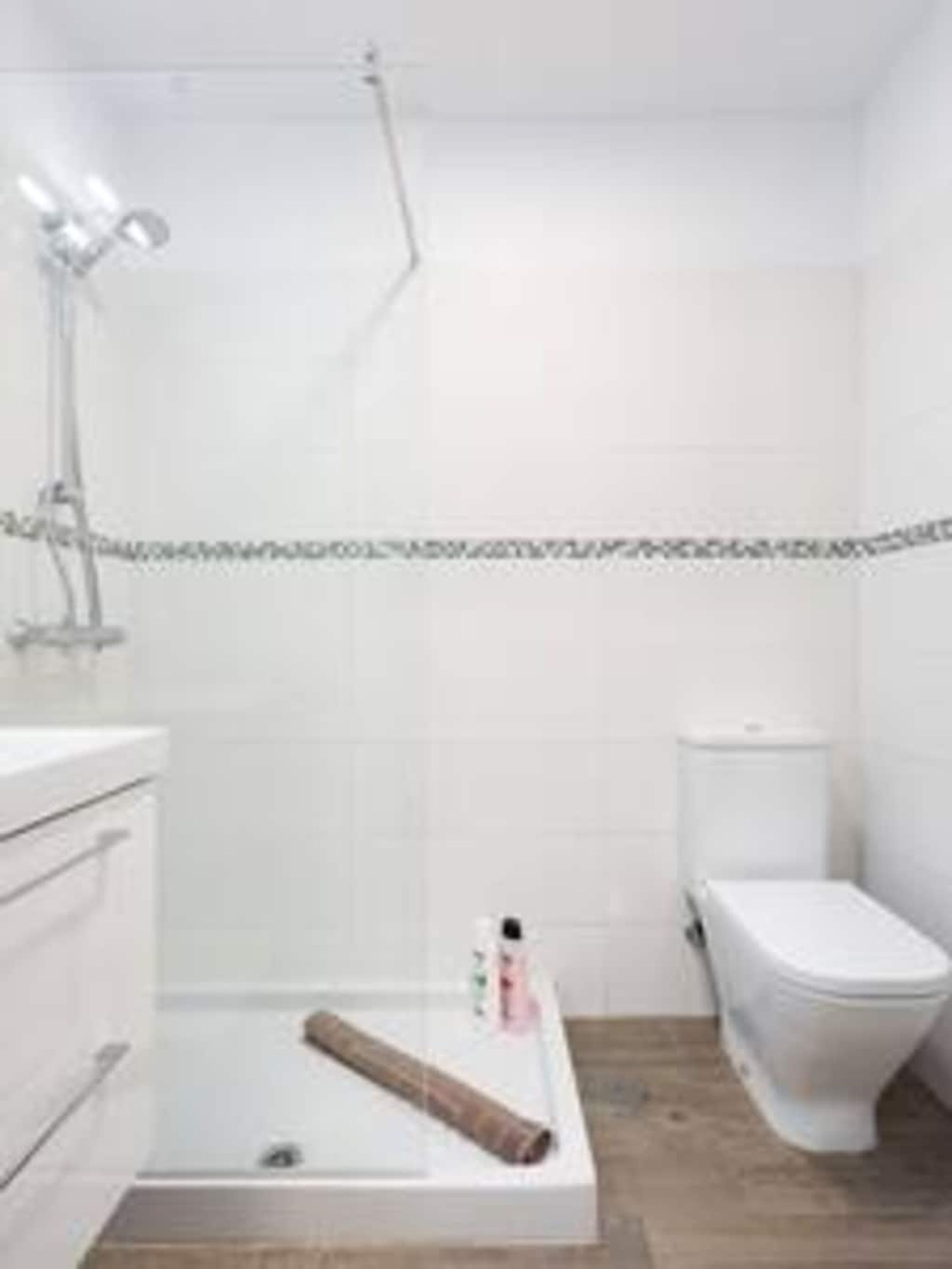 Ein Badezimmer mit Dusche, Toilette und Waschtisch.