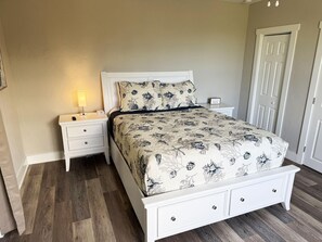 Ein Schlafzimmer mit Bett, Nachttisch und Tür.