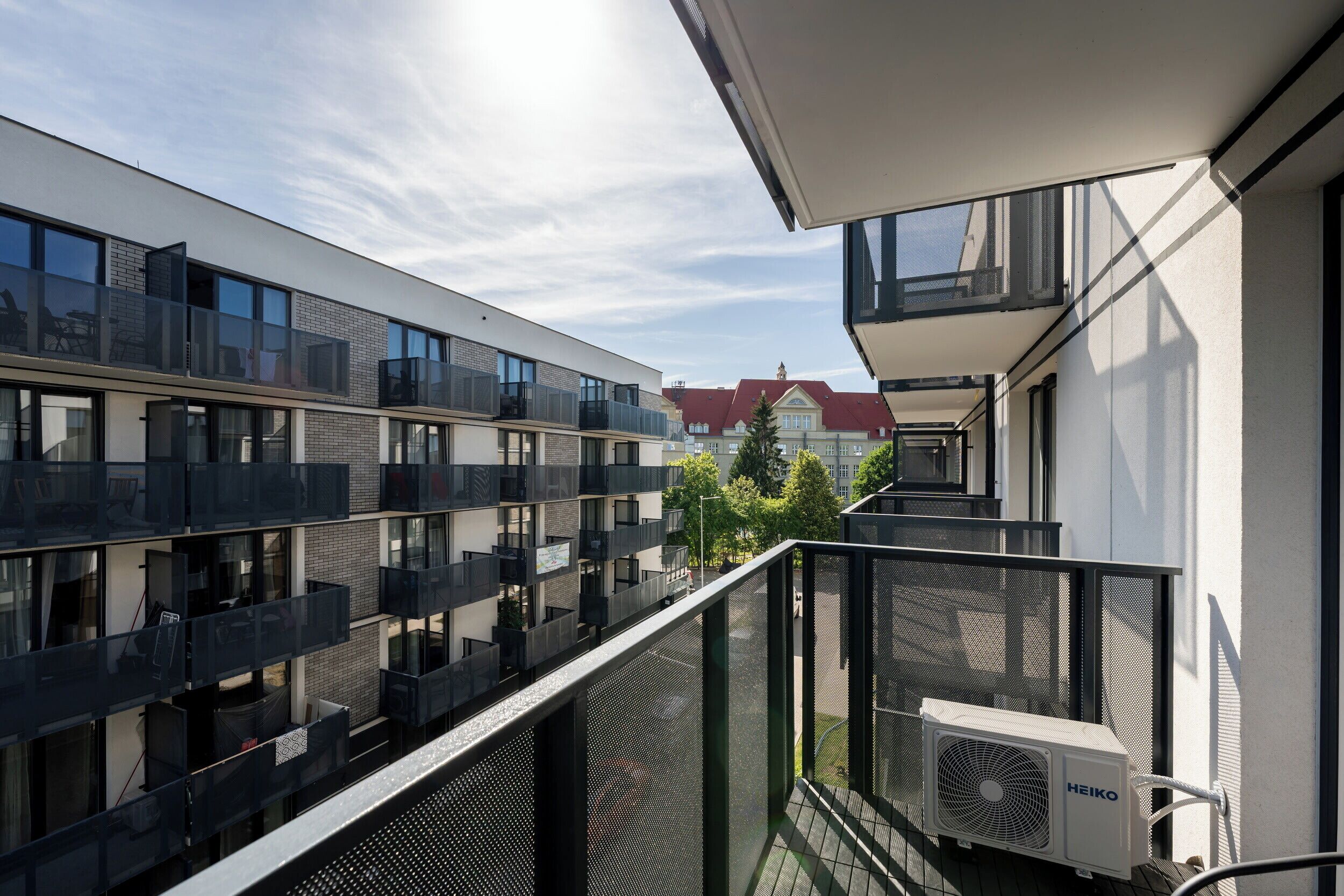 A modern building with multiple balconies and a view of a street.