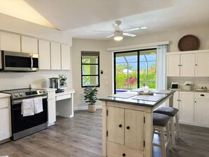A kitchen with a central island, a microwave, an oven, and a ceiling fan. - Golf Retreat - Pool, Spa & Fire Pit (Rotonda West)