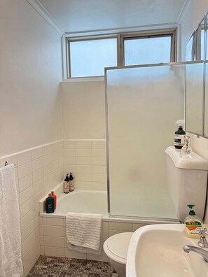 Un bagno con una vasca, un lavandino e uno specchio.