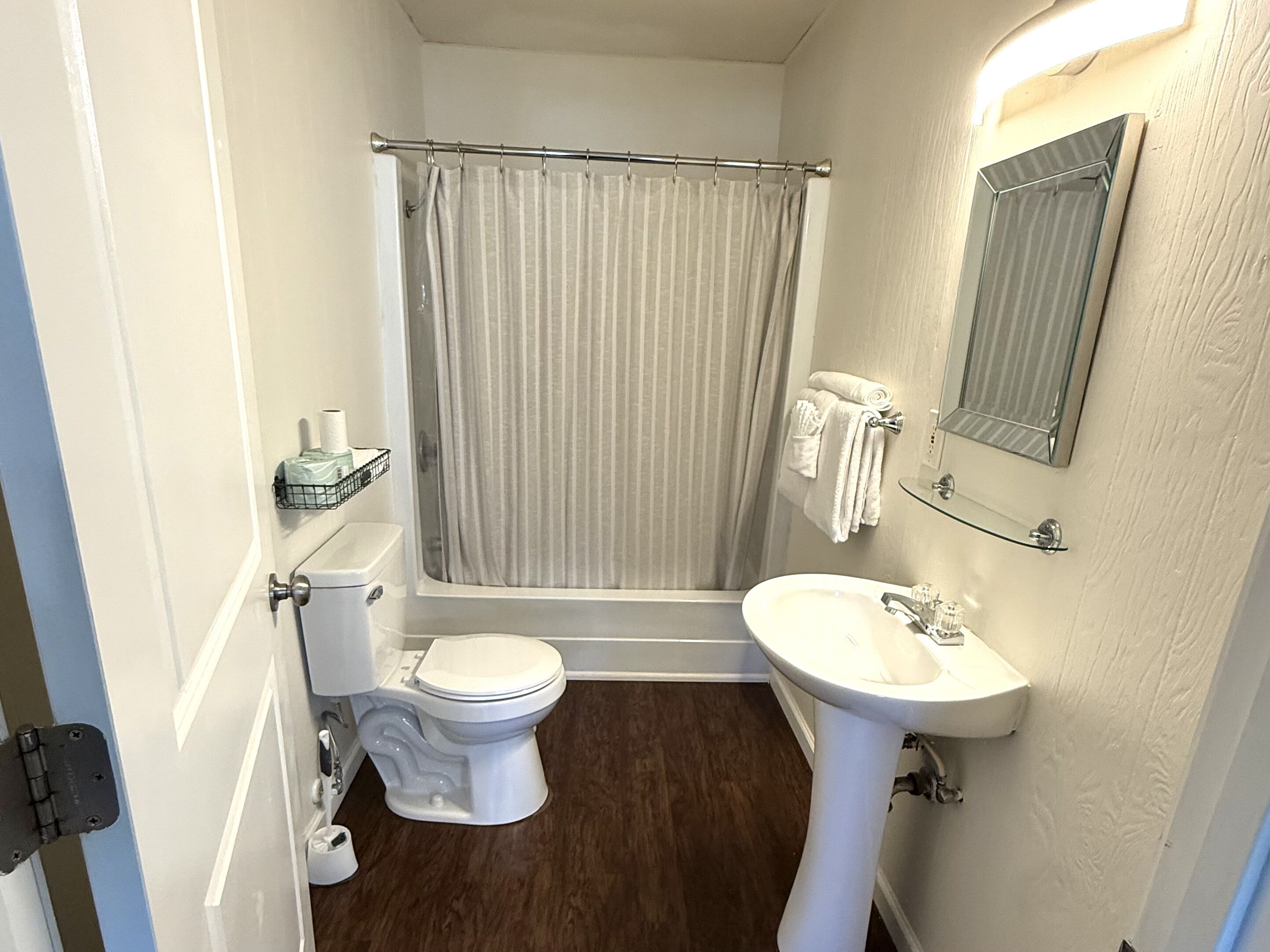 Une petite salle de bain comprenant des toilettes, un lavabo et un rideau de douche.