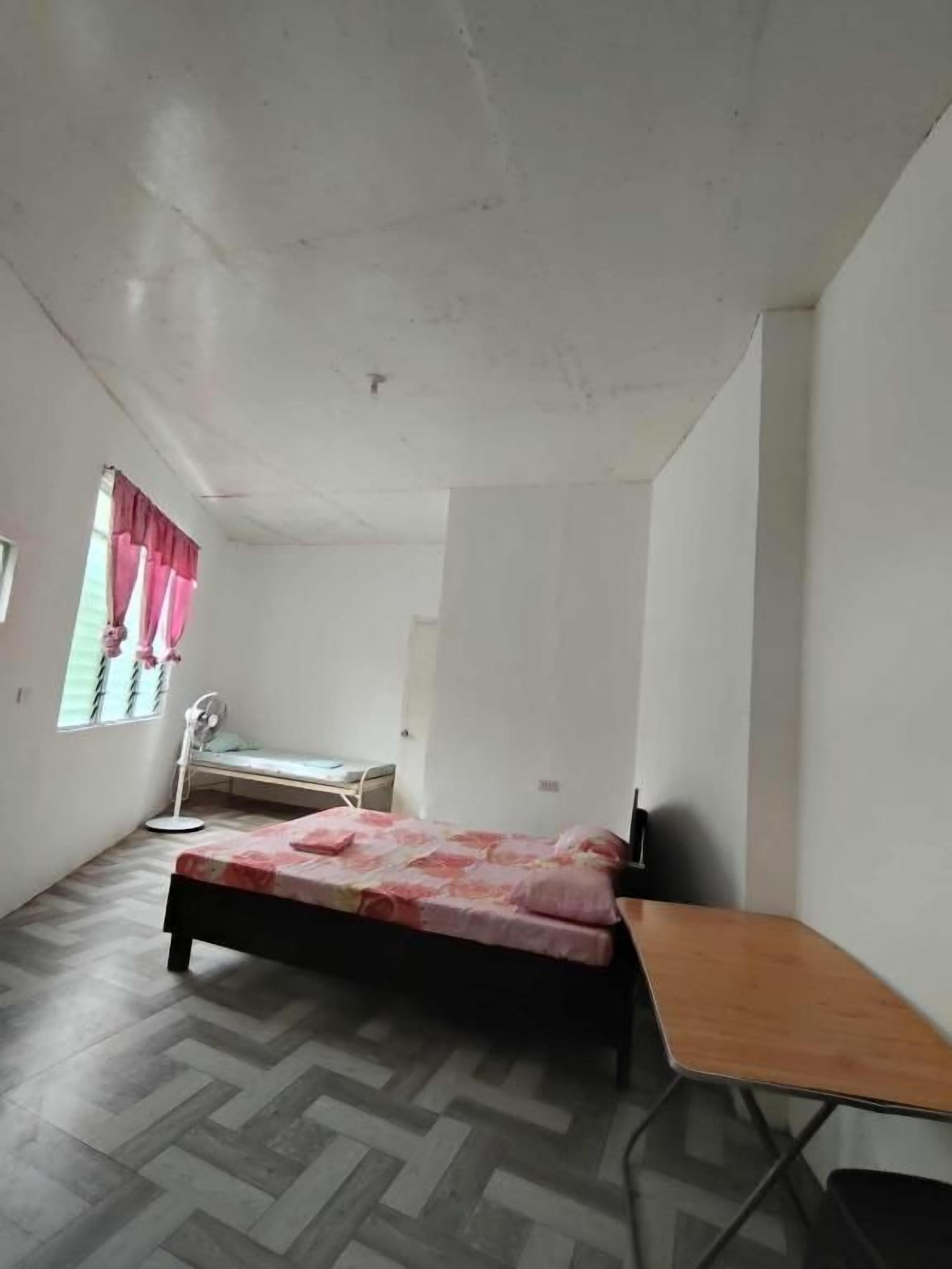 A bedroom with a bed, a wooden table, and a bench.