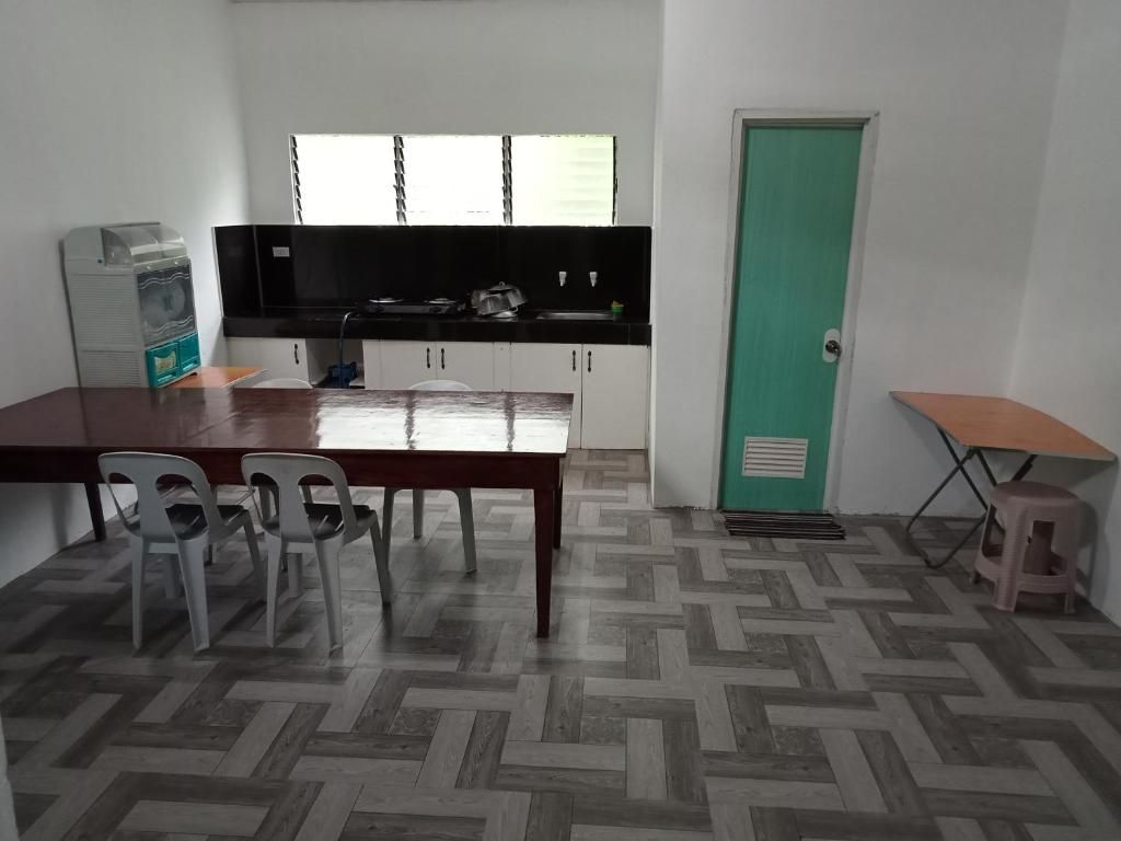 Een kleine keuken met een eettafel, stoelen en een klein krukje.