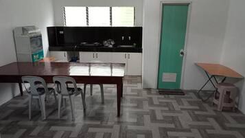Een kleine keuken met een eettafel, stoelen en een klein krukje.
