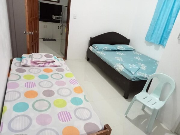 A bedroom with a bed, a chair, and a wardrobe.