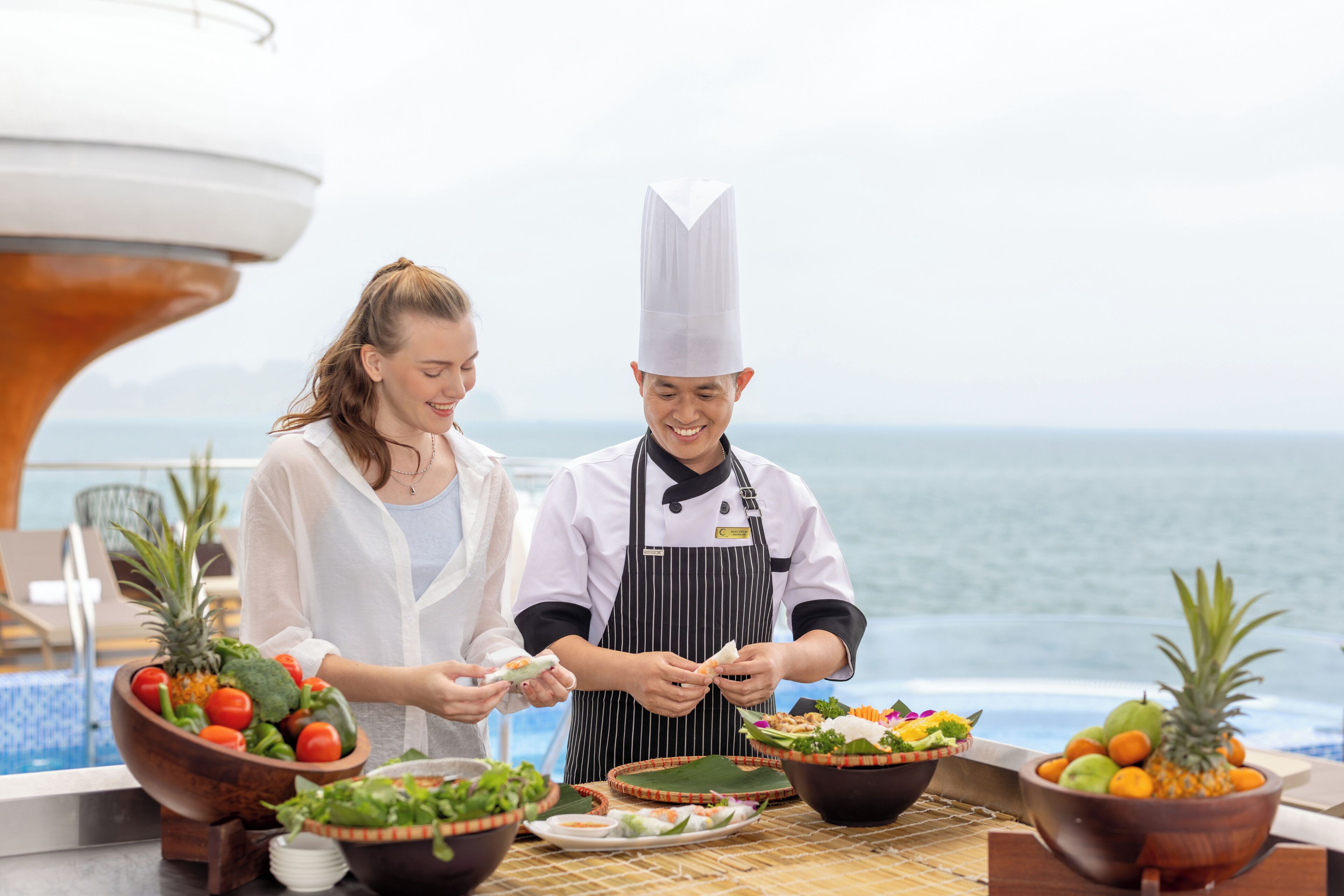 A chef preparing food on a boat with a view of the ocean.