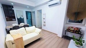 Ein modernes Wohnzimmer mit einer Couch, einem Esstisch und einer kleinen Küchenzeile.