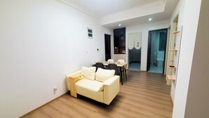 Ein modernes Wohnzimmer mit einer Couch, einem Esstisch und einer Küchenzeile.