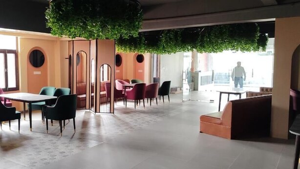 Un interior moderno con comedor, asientos y vistas a través de un espacio abierto.