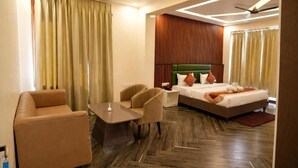 Una habitación de hotel con cama, sofá, una mesita y una mesita de noche.