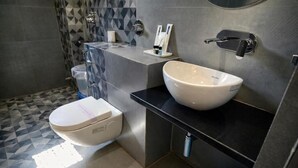 Un baño moderno con inodoro, lavabo y ducha.