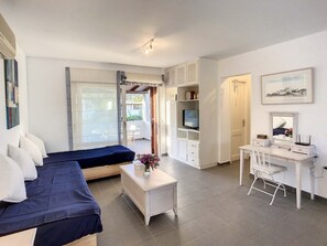 Habitació amb llit, escriptori, televisió i cadira.