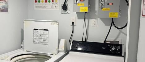 A laundry room with a washing machine, dryer, and a wall-mounted washer and dryer unit.