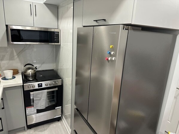 A kitchen with a stainless steel refrigerator, oven, and microwave.