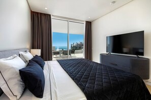 A hotel room with a bed, a TV, a desk, and a view of the city. - Jacarandas Breeze Palo Alto (Ojen)