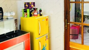 A kitchen with a microwave, a yellow refrigerator, and a blue wall decoration. - 2-bedroom apartment in charming Dakar with AC and comfort (Dakar)